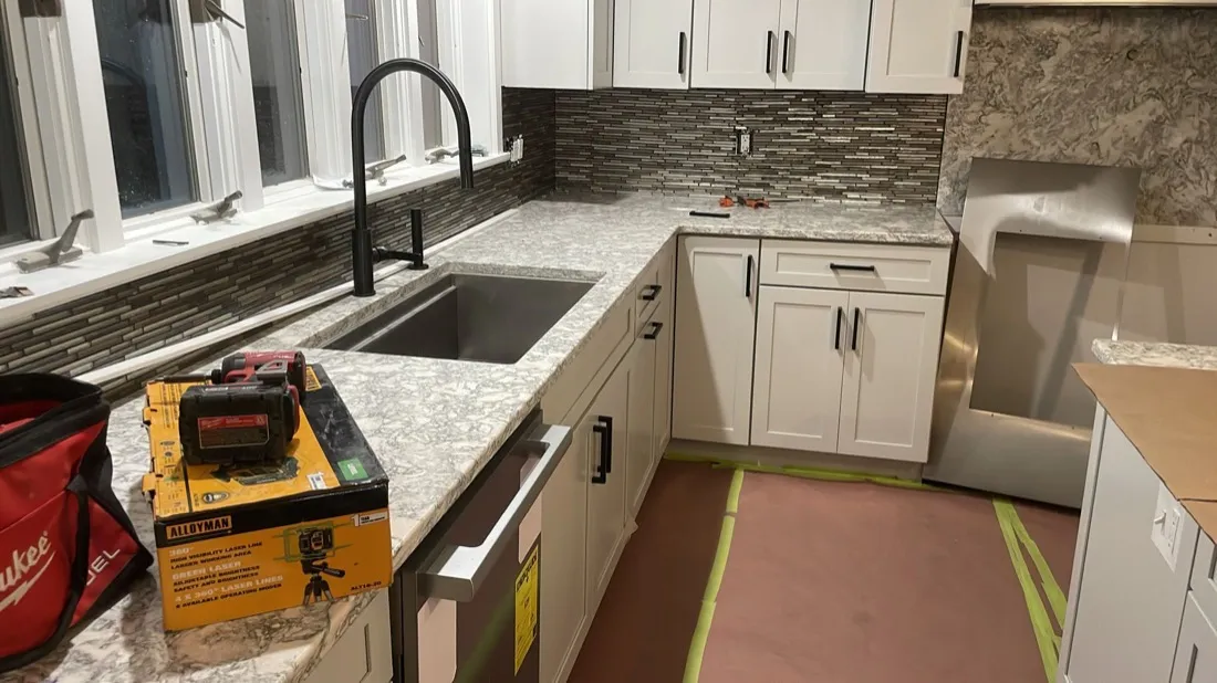 Linear mosaic tile backsplash installation in a Boston kitchen